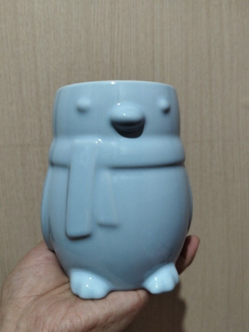 Light Blue Penguin Ceramic Mug with Handle (Category: Coffee & Tea Tableware) located in Caloocan City. Submitted by agr_shop (Listing ID 1465283785, Image 2). Description: - Adorable light blue penguin-shaped ceramic mug - Features cute 3D details: beak, feet, wings, and a cozy wrapped scarf - Comfortable curved handle on the side - Smooth and glossy finish all over - Ideal gift for penguin lovers and coffee drinkers - Hand wash recommended to p