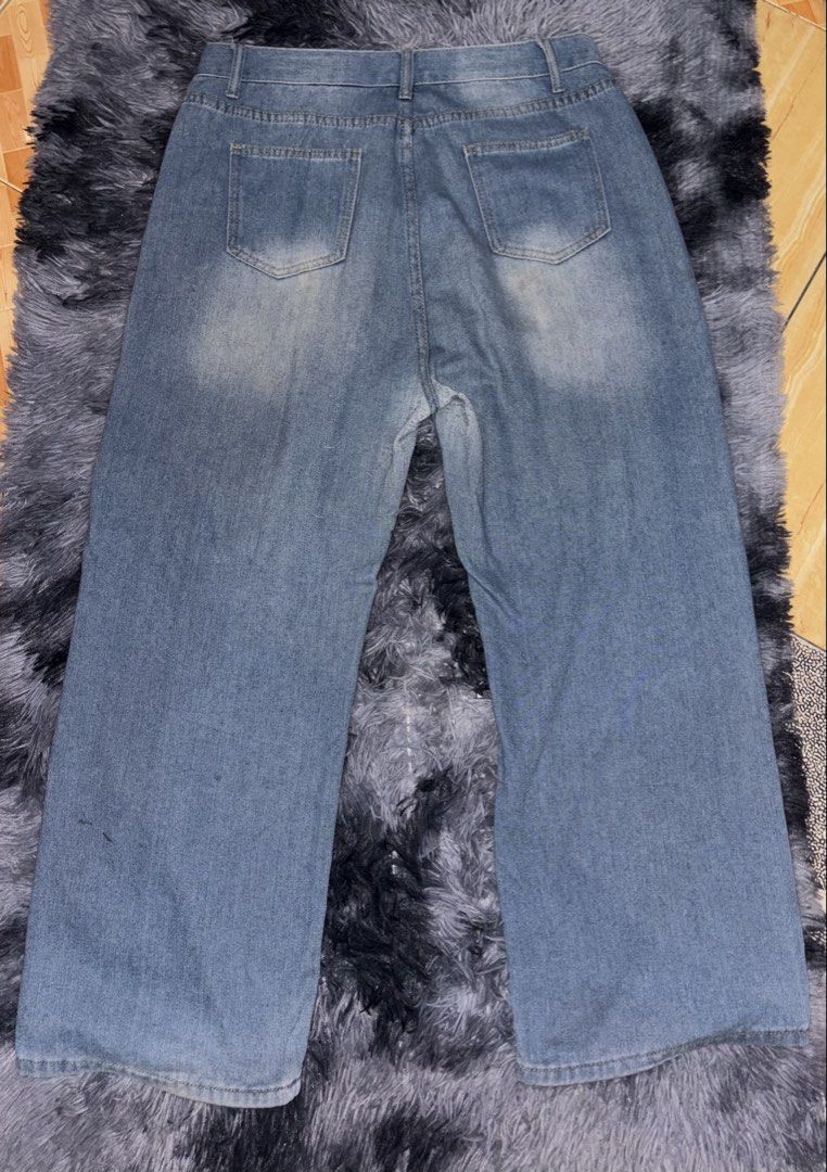 Light Blue Wide Leg Denim Jeans (Category: Jeans) located in Manila. Submitted by michellebu59261 (Listing ID 1465197113, Image 2). Description: - Style: Wide leg fit with mid-rise waist - Wash: Light wash denim with faded details on thighs and back - Closure: Button closure and zip fly - Pockets: Two front pockets, one coin pocket, and two back patch pockets - Perfect for comfortable everyday casual wear.