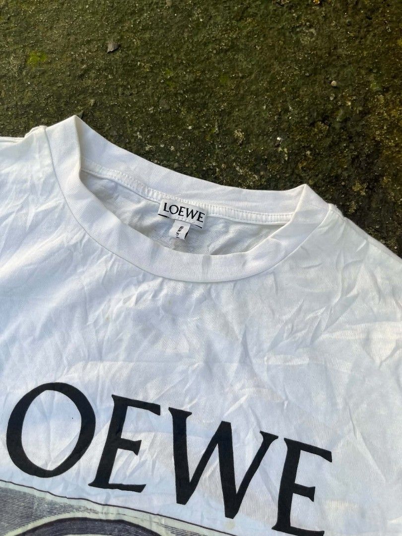 Loewe Graphic Print T-Shirt White (Category: Shirts) located in Manila. Submitted by sls.wear (Listing ID 1465208052, Image 2). Description: - Brand: Loewe - Color: White - Design: Bold portrait graphic with branding on the front - Material: 100% Cotton main fabric, 95% Cotton / 5% Elastane rib - Fit: Regular fit, short sleeve - Origin: Made in Portugal - Comfort: Super soft and perfect for daily wear.