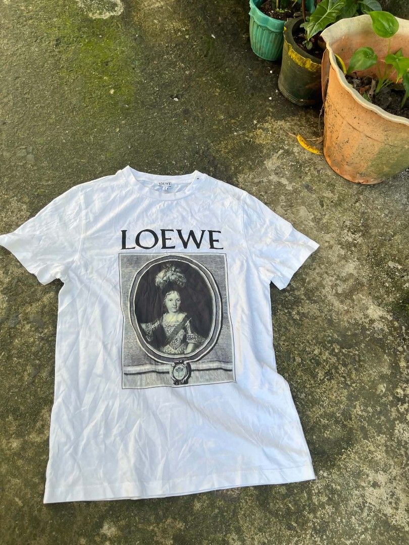 Loewe Graphic Print T-Shirt White (Category: Shirts) located in Manila. Submitted by sls.wear (Listing ID 1465208052, Image 1). Description: - Brand: Loewe - Color: White - Design: Bold portrait graphic with branding on the front - Material: 100% Cotton main fabric, 95% Cotton / 5% Elastane rib - Fit: Regular fit, short sleeve - Origin: Made in Portugal - Comfort: Super soft and perfect for daily wear.