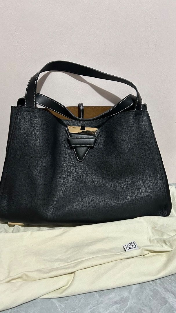 Loewe Hammock Tote Bag Black Leather (Category: Tote Bags) located in Caloocan City. Submitted by belaciao_ (Listing ID 1465358833, Image 1). Description: - Authentic Loewe black pebble-grained calfskin leather bag - Luxurious brown suede interior lining with an inner zip pocket - Elegant gold-tone hardware featuring an engraved logo plate - Structured top handles and a convenient removable shoulder strap - Classic neutral design offering plenty 