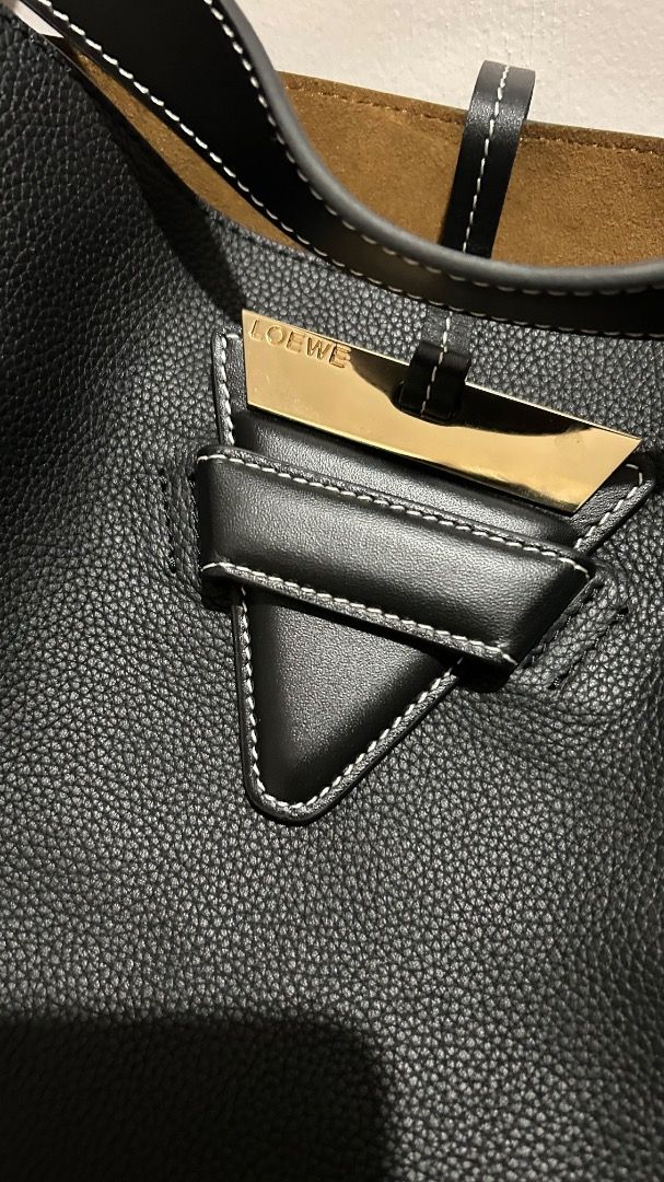 Loewe Hammock Tote Bag Black Leather (Category: Tote Bags) located in Caloocan City. Submitted by belaciao_ (Listing ID 1465358833, Image 2). Description: - Authentic Loewe black pebble-grained calfskin leather bag - Luxurious brown suede interior lining with an inner zip pocket - Elegant gold-tone hardware featuring an engraved logo plate - Structured top handles and a convenient removable shoulder strap - Classic neutral design offering plenty 