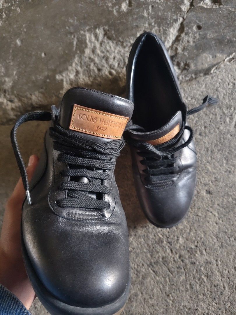 Louis Vuitton Black Leather Sneakers (Category: Sneakers & Footwear) located in Manila. Submitted by joshespino71762 (Listing ID 1465178577, Image 1). Description: Black leather sneakers by Louis Vuitton. Tan leather patch on the tongue with embossed logo branding. Louis Vuitton text stamped along the midsole. Gum rubber soles with LV square monogram detail on the bottom. Black laces. Regular fit, classic low-top silhouette..