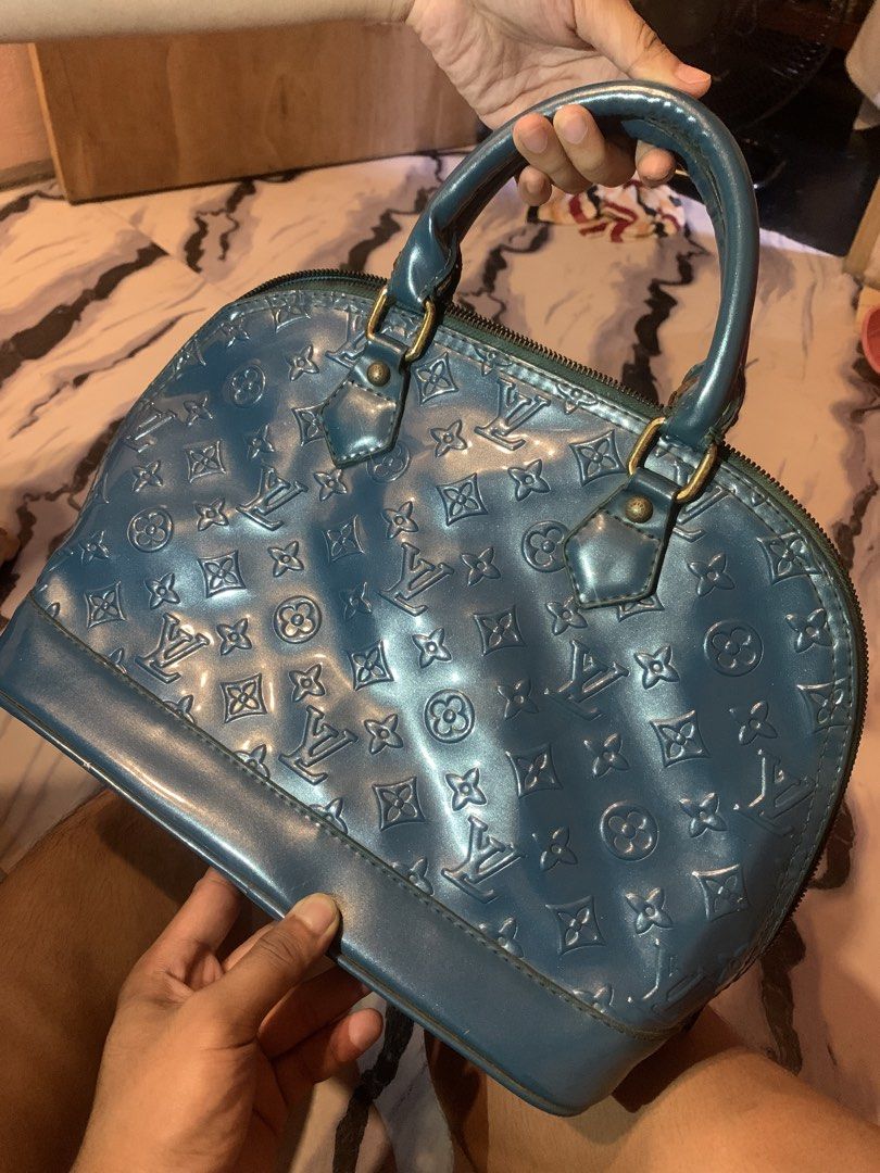 Louis Vuitton Monogram Vernis Alma Blue Handbag (Category: Luxury Bags & Wallets) located in Manila. Submitted by jay_seller (Listing ID 1465339032, Image 1). Description: - Authentic Louis Vuitton Monogram Vernis Alma bag in a striking blue shade - Crafted from glossy patent leather with the iconic embossed monogram pattern - Structured design featuring dual top handles and gold-tone hardware - Zip-around closure opens to a spacious teal suede-l