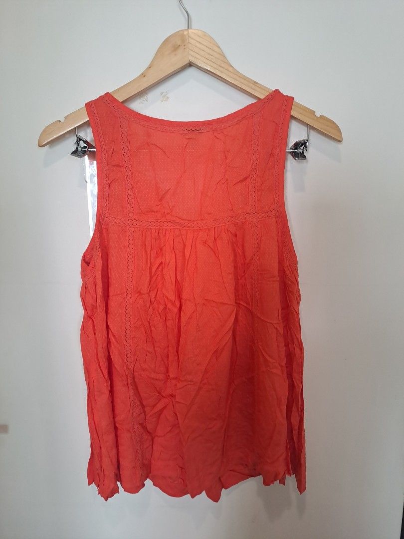 Lucky brand sleeveless (Category: Sleeveless) located in Manila. Submitted by joanbalde39643 (Listing ID 1465246593, Image 3). Description: This is a vibrant coral-orange sleeveless tank blouse from the brand Lucky Brand. It features a bohemian-inspired split V-neckline with delicate crochet lace trimming around the collar and a lightly pleated, flowing silhouette..
