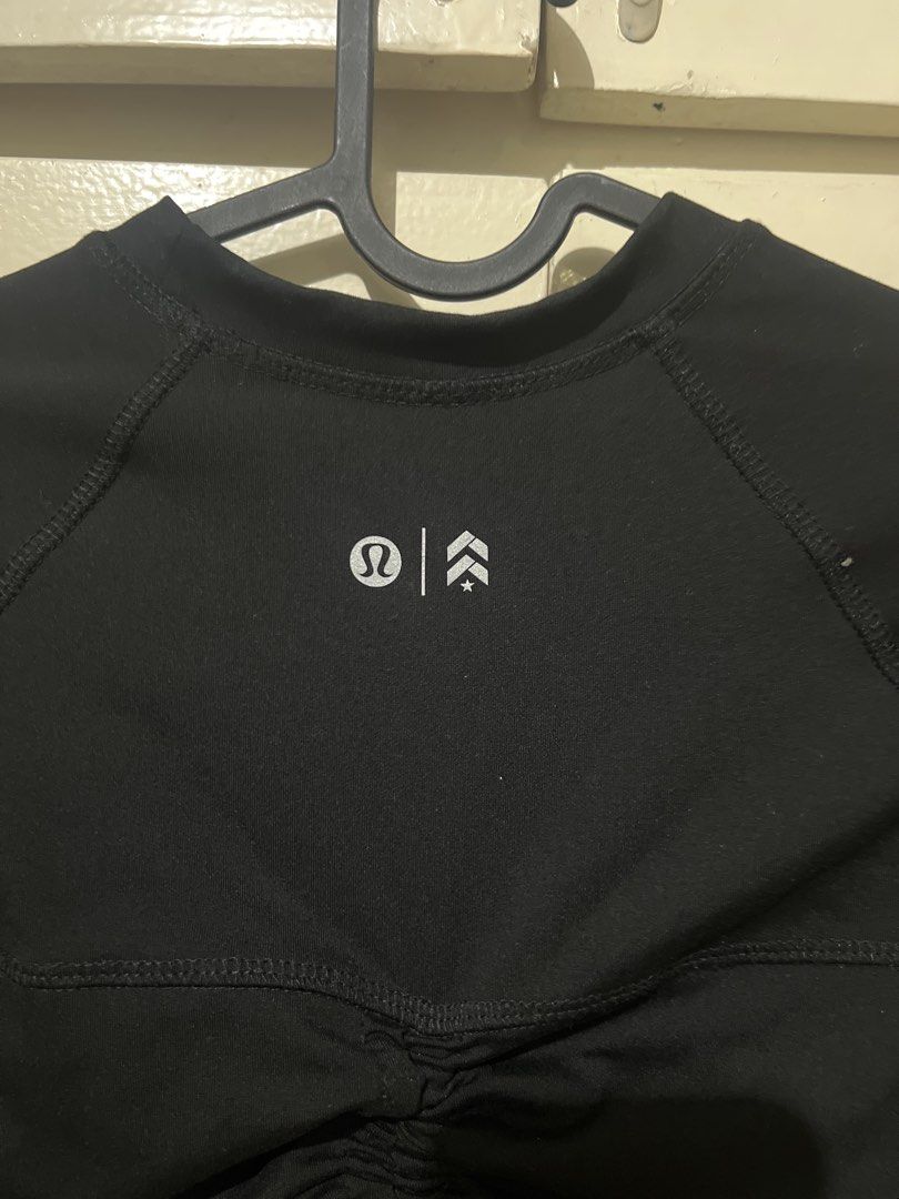 Lululemon Black Activewear Top With Back Cinch (Category: Activewear) located in Quezon City. Submitted by shadecluttersss (Listing ID 1465293086, Image 1). Description: - Brand: Lululemon - Color: Black - Style: Short sleeve athletic top with crew neck and raglan sleeves - Feature: Unique adjustable cinch drawstrings across the back panel - Details: Reflective brand logo and chevron icon near the upper back collar - Fabric: Lightweight and breat