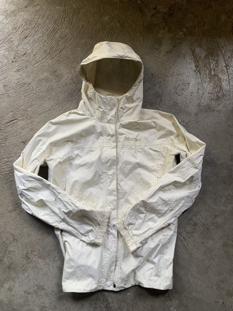 Marmot Cream Hooded Rain Jacket (Category: Coats, Jackets and Outerwear) located in Manila. Submitted by armamentoj94205 (Listing ID 1465176364, Image 1). Description: - Brand: Marmot - Color: Cream - Style: Lightweight hooded rain jacket with full zip closure and adjustable hood - Branding: Embroidered logo on chest and small logo patch on back yoke - Condition: Good practical condition, with minor interior lining peeling along the collar seam -