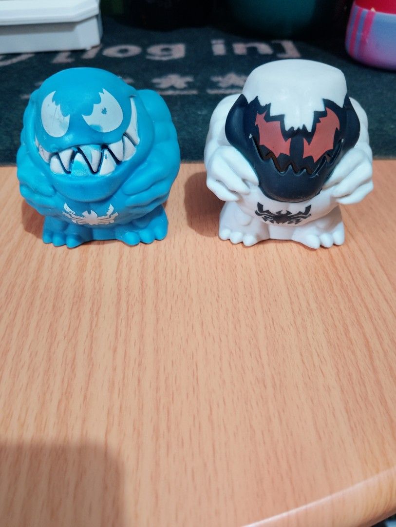 Marvel Venom Squishers Figures (Category: Figurines & Statues) located in Manila. Submitted by boyhet.thrift15 (Listing ID 1465323646, Image 1). Description: Two Marvel Venom figures. Blue one has classic white eyes and spider logo on chest. White one features dark mask with red eyes and spider logo. Squeeze style toys with muscular body shapes. Hasbro 2019 copyright stamped on the bottom of the blue figure. Minor paint wear on the teeth and eyes