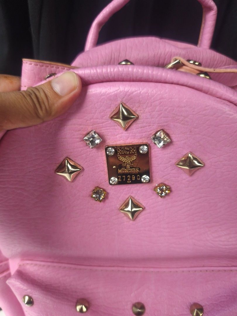 MCM Pink Studded Backpack (Category: Backpacks) located in General Mariano Alvarez. Submitted by crisshane_13 (Listing ID 1465246138, Image 2). Description: - Authentic MCM backpack in eye-catching bright pink leather - Covered in edgy metal studs and sparkling crystal embellishments - Luxurious gold-tone hardware and iconic MCM logo plates - Practical storage: main zip compartment, front zip pocket, and interior zip pocket - Comfortable top grab
