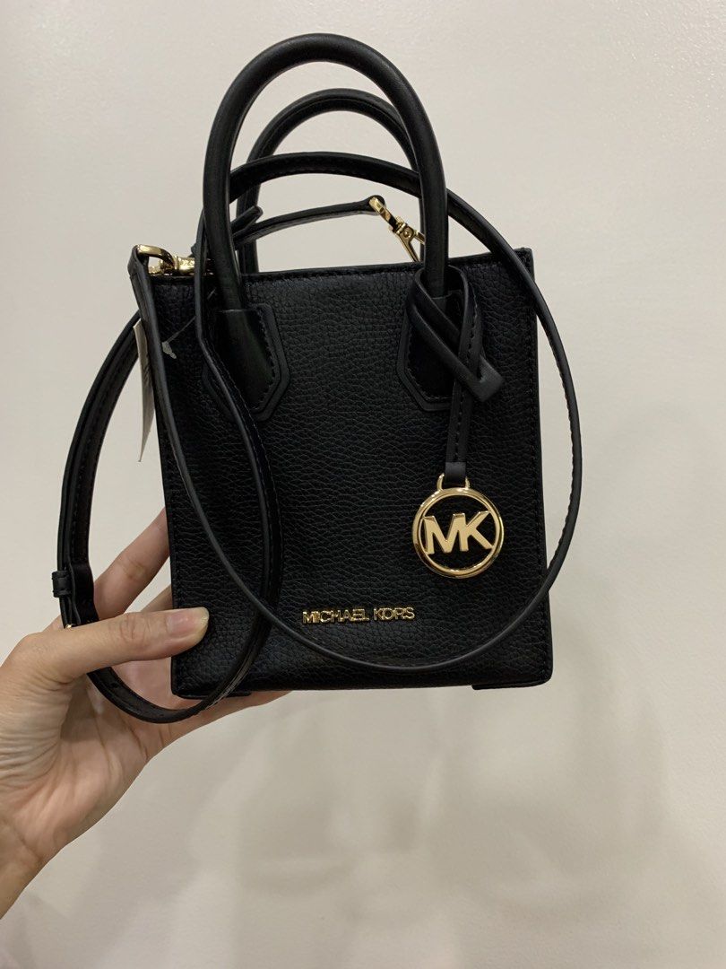 Michael Kors Black Leather Mini Tote Bag (Category: Luxury Bags & Wallets) located in Pasay City. Submitted by slashed (Listing ID 1465233821, Image 3). Description: Black pebble leather mini tote bag from Michael Kors. Gold hardware accents with MK logo charm hanging on the front. Double top handles plus an adjustable removable crossbody strap. Magnetic snap closure on top, black fabric interior lining with slip pockets. Compact size, great for 