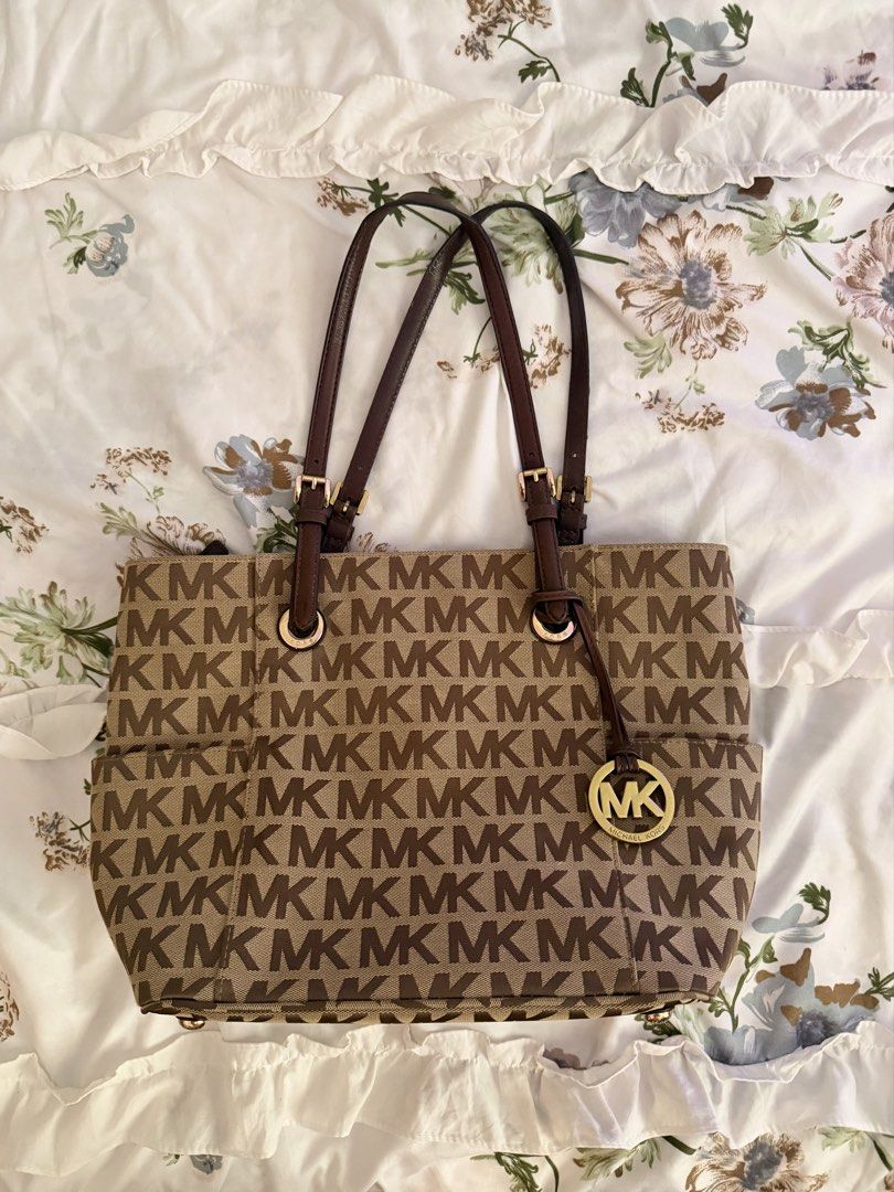 Michael Kors MK Monogram Brown Bag (Category: Shoulder Bags) located in Las Pinas. Submitted by kitkat333_ (Listing ID 1465314385, Image 1). Description: - Authentic Michael Kors tote in classic brown monogram - Elegant dark brown leather straps and gleaming gold-tone hardware, complete with MK charm - Intact leather - No stains/Signs of usage! - Secure top-zip closure to keep your belongings safe - Spacious fabric-lined interior with a middle zi