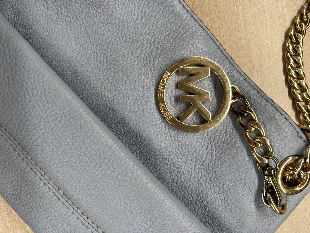 MICHAEL KORS (MK) Sling Bag 💙 (Category: Shoulder Bags) located in Tanza. Submitted by vhies_closet24 (Listing ID 1465182671, Image 2). Description: MICHAEL KORS (MK) Sling Bag 💙 Color: Light Blue With gold-tone chain strap 📌 Condition: Pre-loved • Has some faded areas and visible stains (see photos) • Still usable and overall intact • Selling as-is, please manage expectations RFS: Decluttering / no longer used.