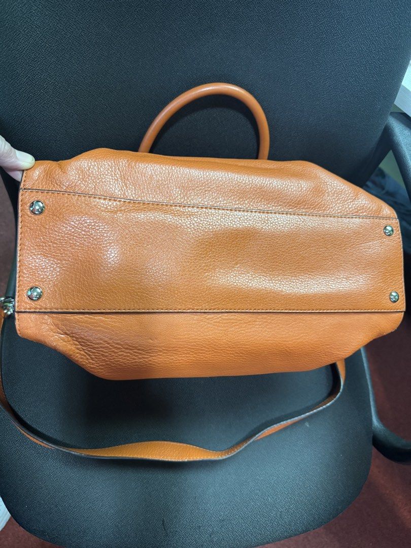Michael Kors Orange Handbag Satchel (Category: Luxury Bags & Wallets) located in Pasig City. Submitted by bgilagan (Listing ID 1465197140, Image 3). Description: - Brand: Michael Kors - Material: Premium tan pebbled leather - Hardware: Sleek silver-tone with branding plate - Straps: Double top handles and a long shoulder strap - Interior: Multiple compartments with signature MK logo fabric lining, zip pockets, and slip pouches - Exterior: Protect