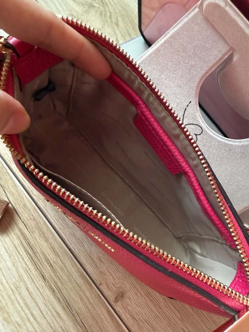 Michael Kors Pink Chain Strap Shoulder Bag (Category: Luxury Bags & Wallets) located in San Pedro. Submitted by silverlion-4d46 (Listing ID 1465208555, Image 3). Description: - Brand: Michael Kors - Material: Bright pink pebbled leather - Hardware: Gold-tone accents with chunky chain strap and hanging padlock charm - Closure: Top zipper closure - Structure: Holds its shape well with a structured base - Capacity: Compact main compartment, great fo