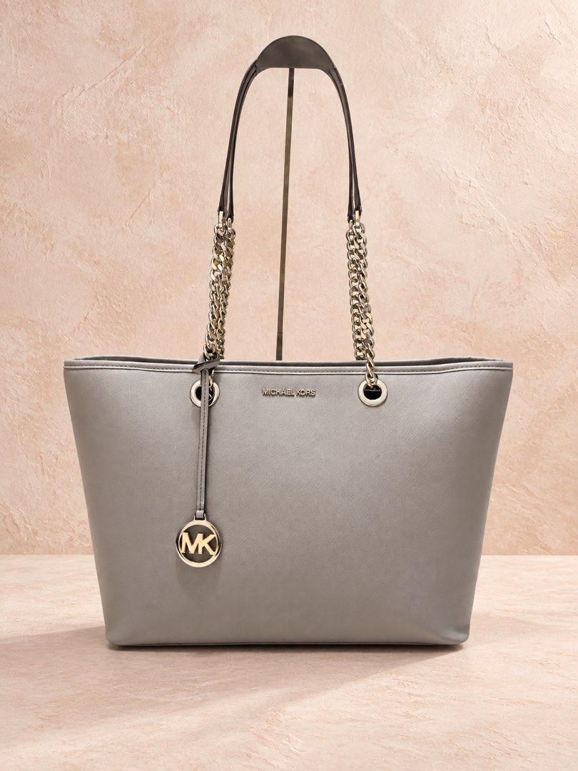 Michael Kors Tote Bag (Category: Shoulder Bags) located in Makati City. Submitted by stylehub.mnl (Listing ID 1465187408, Image 1). Description: 👜 Michael Kors Grey Saffiano Tote Bag Elegant, timeless & perfect for everyday use. 🤍 Authentic Michael Kors tote bag in a sophisticated grey/taupe shade, featuring the classic saffiano-style textured finish and signature chain handles. ✨ Details: • Michael Kors branding • Silver-tone chain handles • S