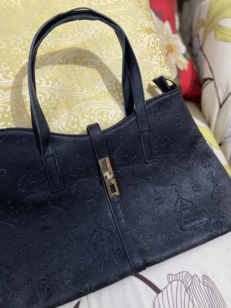 MICHAELA Black Monogram Embossed Shoulder Bag/Tote (Category: Shoulder Bags) located in Guinobatan. Submitted by jadieee_young22 (Listing ID 1465226151, Image 2). Description: - preloved condition - color: black - heart monogram pattern embossed on leather - front strap with turn-lock accent - spacious interior - Flaws: minor peeling along the handles edge coating dm if interested:) rfs: decluttering (cleaning out old stuffs).