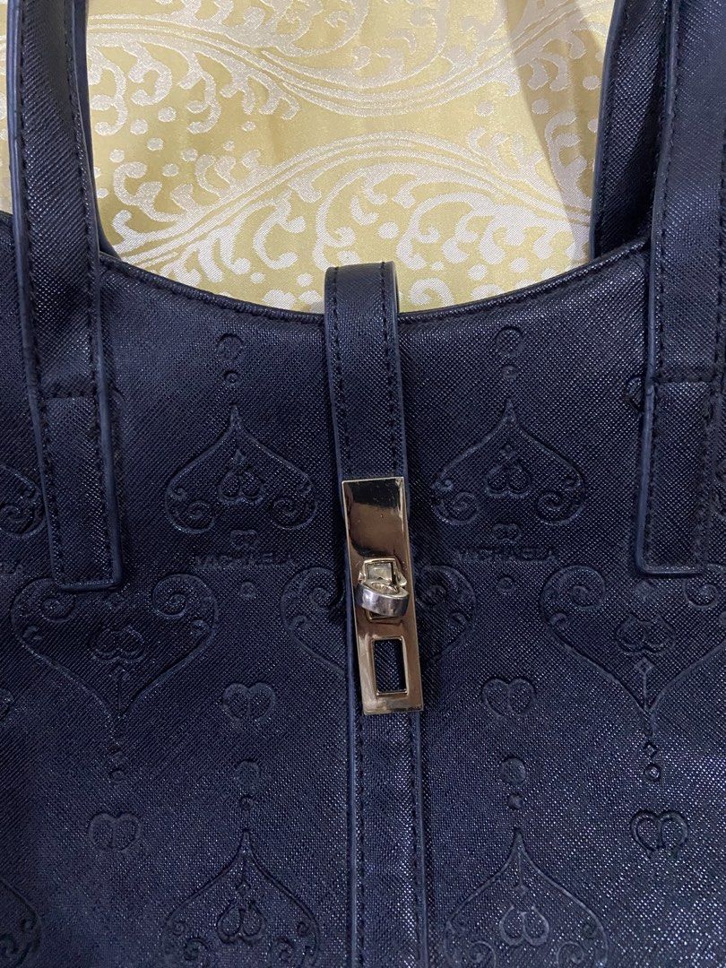 MICHAELA Black Monogram Embossed Shoulder Bag/Tote (Category: Shoulder Bags) located in Guinobatan. Submitted by jadieee_young22 (Listing ID 1465226151, Image 3). Description: - preloved condition - color: black - heart monogram pattern embossed on leather - front strap with turn-lock accent - spacious interior - Flaws: minor peeling along the handles edge coating dm if interested:) rfs: decluttering (cleaning out old stuffs).