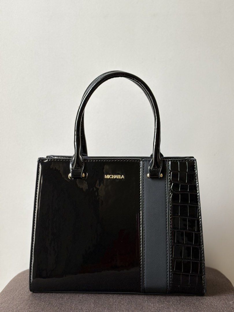 MICHAELA Crocodile Handbag | Black (Category: Purses & Pouches) located in Manila. Submitted by thecloseteditph (Listing ID 1465258185, Image 1). Description: Authentic MICHAELA Crocodile Structured Handbag • Black color • Crocodile-effect patent finish • Structured design • Gold-tone hardware • Top handle • Comes with matching pouch & detachable strap • Clean and well-maintained • Excellent pre-owned condition • No major flaws 📌 Handbag + match