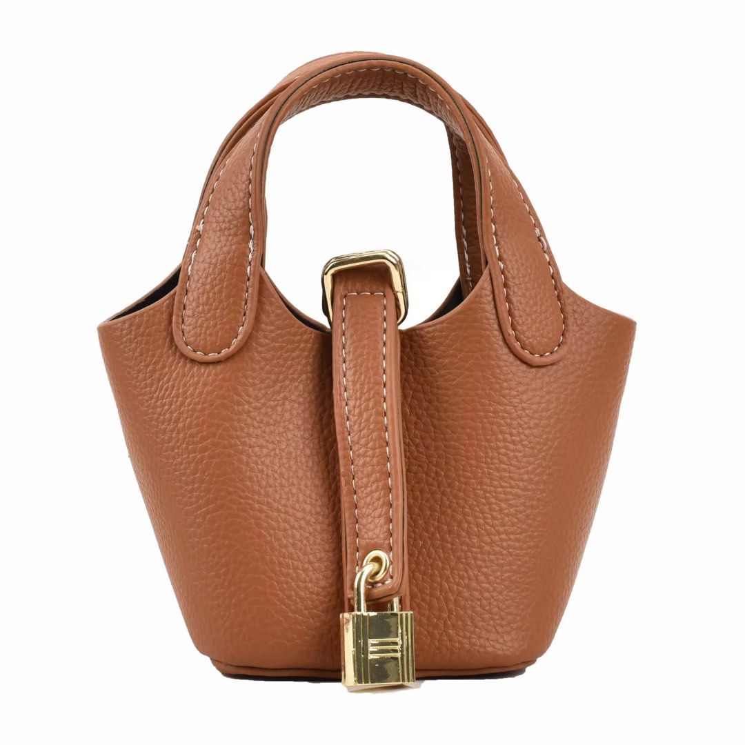 Mini Bucket Bag Pic0tin Brown (Category: Cross-body Bags) located in Orani. Submitted by dejaniuph (Listing ID 1465173062, Image 1). Description: - Textured brown leather mini bucket bag - Elegant gold-tone hardware with decorative front lock - Versatile design with top handles and thin adjustable shoulder strap - Perfect compact size for crossbody or hand carry - Impeccable condition: clean interior and exterior with no leather scuffs.