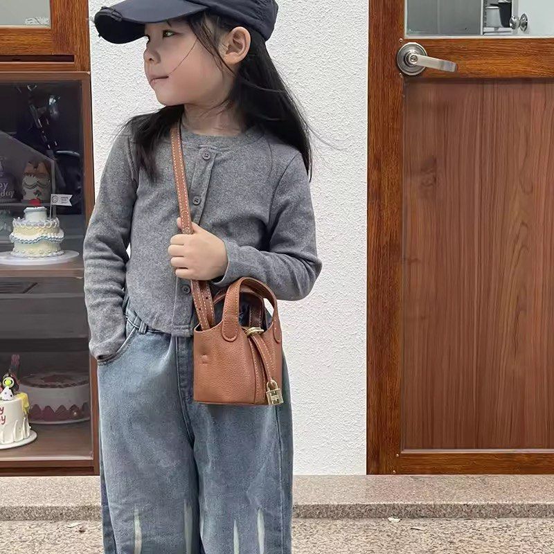 Mini Bucket Bag Pic0tin Brown (Category: Cross-body Bags) located in Orani. Submitted by dejaniuph (Listing ID 1465173062, Image 3). Description: - Textured brown leather mini bucket bag - Elegant gold-tone hardware with decorative front lock - Versatile design with top handles and thin adjustable shoulder strap - Perfect compact size for crossbody or hand carry - Impeccable condition: clean interior and exterior with no leather scuffs.