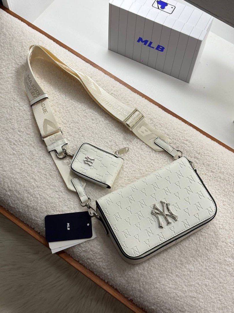MLB Crossbody Bag Set Sling Bag (Category: Sling Bags) located in Manila. Submitted by sanghaya.mnl (Listing ID 1464923317, Image 2). Description: - Includes a matching mini pouch coin purse for extra storage - Features premium metal Yankees logo hardware on the front - Comfortable, adjustable wide webbing strap included - Color options: Classic Black or Clean White - Original branding tags attached.