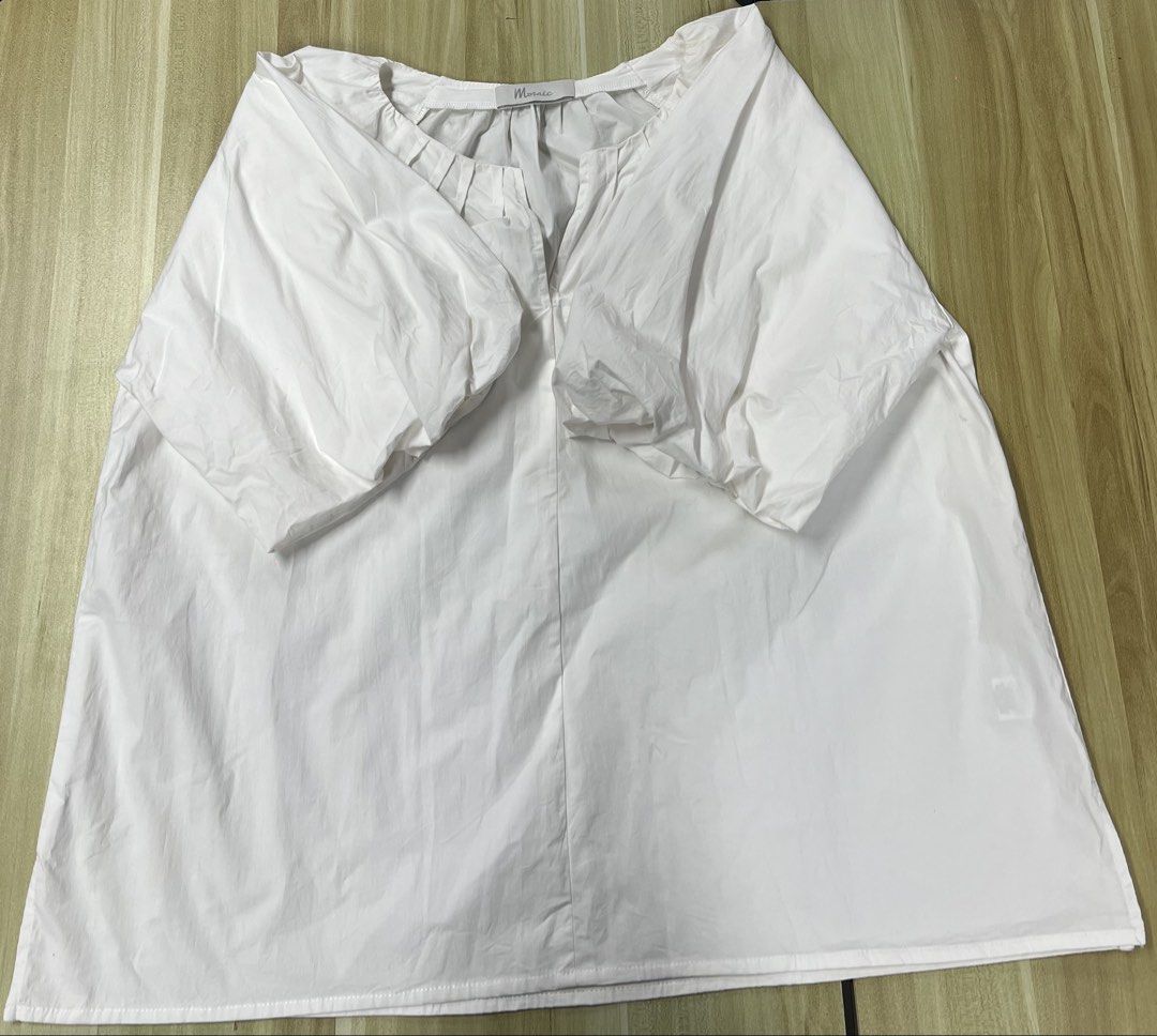 Mosaic White Puff Sleeve Blouse (Category: Blouses) located in Manila. Submitted by issie_07 (Listing ID 1465211818, Image 1). Description: - Color: Mosaic White - Fit: Loose and flowy through the body - Sleeves: Short puff sleeves - Neckline: Gathered with a small front slit - Fabric: Crisp, lightweight, and breathable cotton-like material - Condition: Excellent, with a clean collar tag.