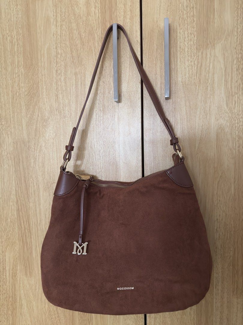MOSSDOOM Brown Suede Shoulder Bag (Category: Shoulder Bags) located in Paranaque City. Submitted by babz0904 (Listing ID 1465216792, Image 2). Description: - Brand: MOSSDOOM - Material: Brown suede with clean fabric lining - Closure: Top zip with elegant gold hardware - Special Detail: Matching M charm on the front zipper - Inclusion: Original branded dust bag - Usage: Ideal daily carryall for work or casual outings.