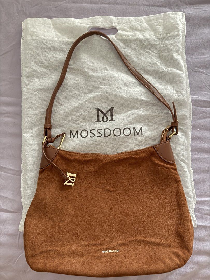 MOSSDOOM Brown Suede Shoulder Bag (Category: Shoulder Bags) located in Paranaque City. Submitted by babz0904 (Listing ID 1465216792, Image 1). Description: - Brand: MOSSDOOM - Material: Brown suede with clean fabric lining - Closure: Top zip with elegant gold hardware - Special Detail: Matching M charm on the front zipper - Inclusion: Original branded dust bag - Usage: Ideal daily carryall for work or casual outings.