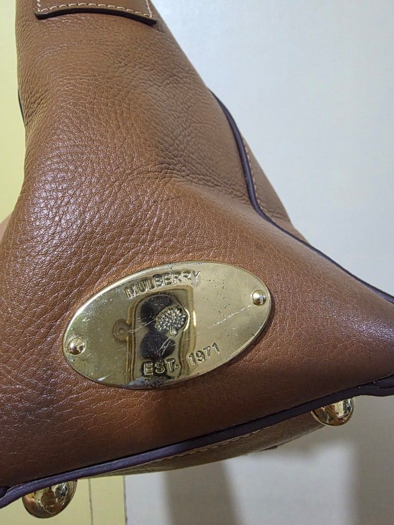 Mulberry Brown Leather Tote Handbag (Category: Luxury Bags & Wallets) located in Dasmarinas. Submitted by closetnqueens (Listing ID 1465296964, Image 2). Description: - Authentic Mulberry brown pebbled leather tote bag - Dual top handles and classic gold-tone hardware - Roomy interior with an inside zipper pocket and serial number tag - Clean lining throughout - Minor surface scratches on the metal plaque plate, but still a gorgeous everyday bag 