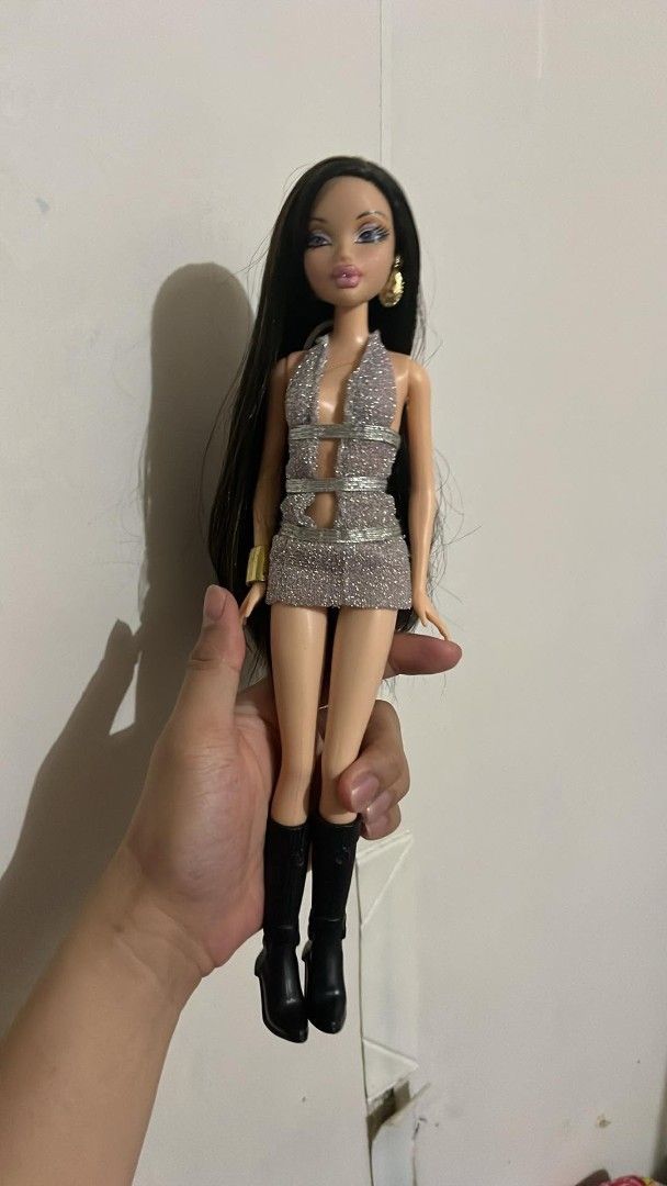 My Scene doll Nolee (Category: Kids Toys) located in Quezon City. Submitted by mysceney2k (Listing ID 1465311409, Image 1). Description: - Character/Brand: My Scene fashion doll - Hair & Makeup: Long dark brown hair with heavy purple eye shadow and pink lips - Outfit: Glittering silver halter dress and knee-high black boots - Accessories: Gold earrings and matching bracelet - Condition: Clean, well-kept, and ideal for display or collection.