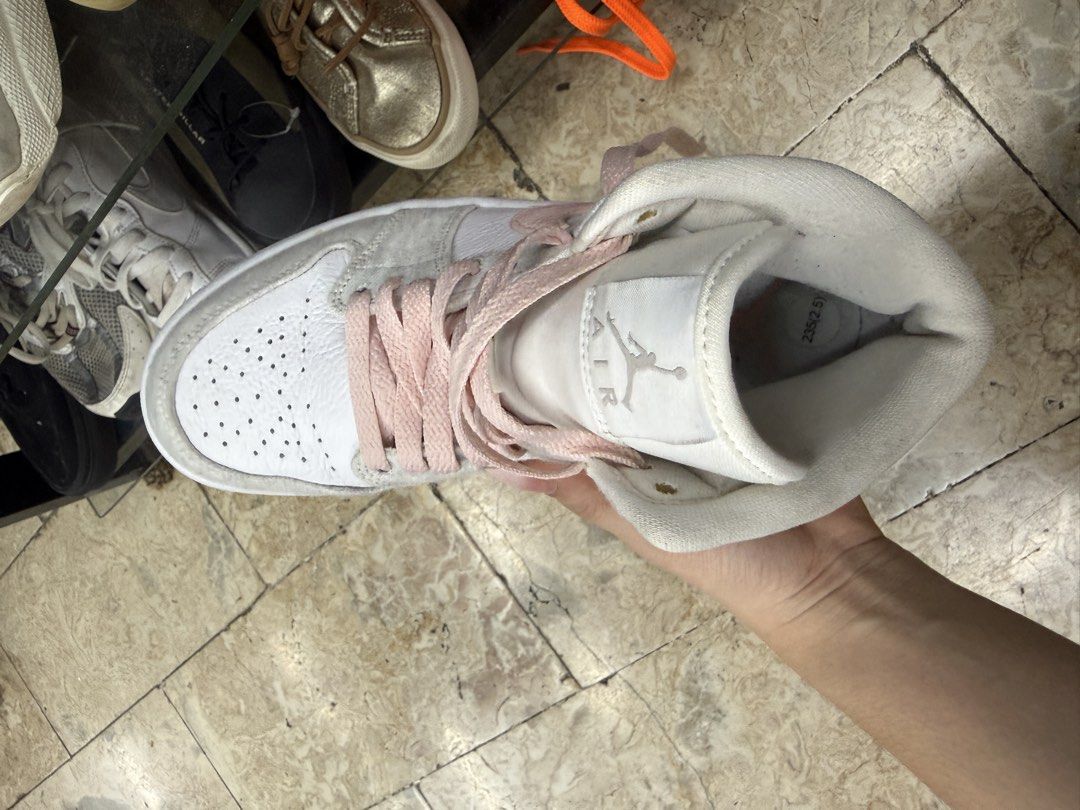 Nike Air Jordan 1 Mid Grey Pink (Category: Sneakers) located in Abucay. Submitted by fastlion.584bdf (Listing ID 1465361613, Image 2). Description: - Brand: Nike Air Jordan 1 Mid - Colorway: White leather base with cozy grey fleece overlays and pastel pink accents (Swoosh, laces, and branding) - Size: 235 / 2.5 (fits approx. US 4Y / EUR 35.5) - Condition: Clean overall, very minimal wear on soles - Features: Classic basketball shoe design with a 