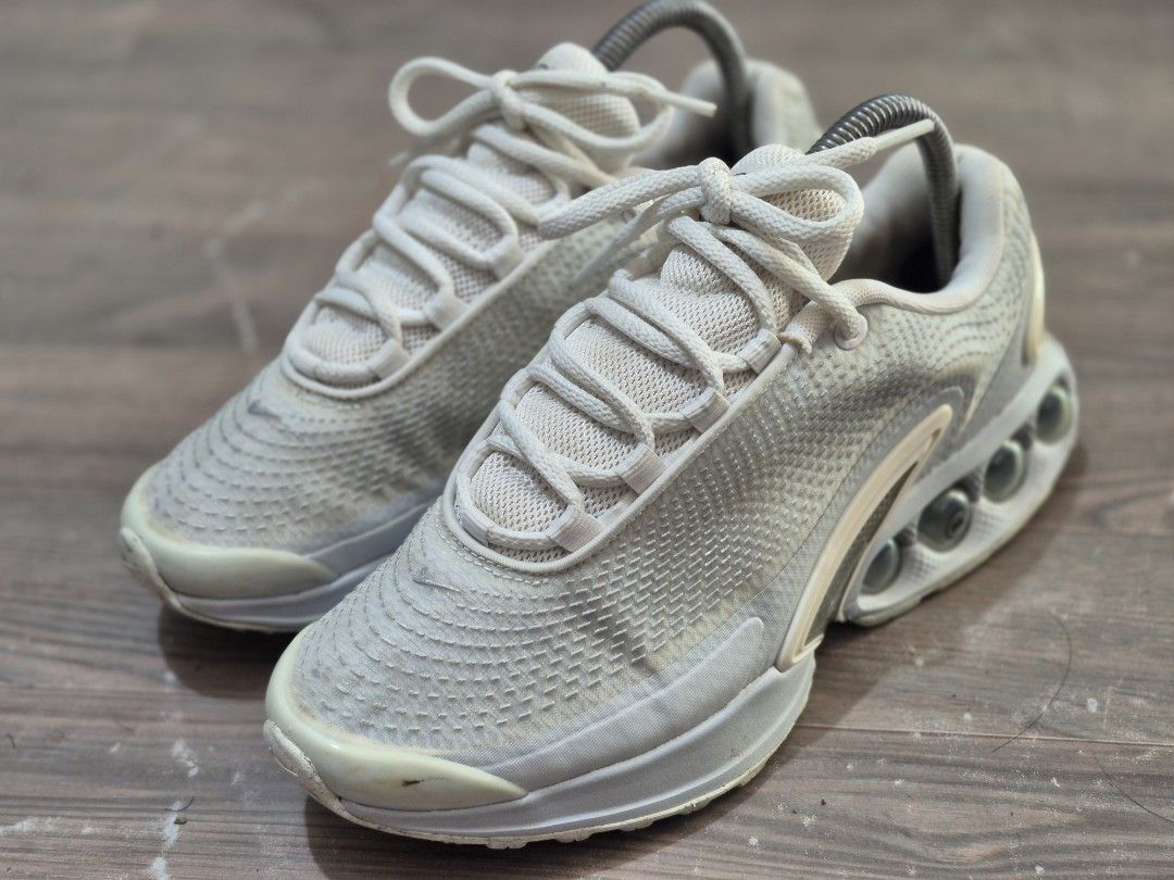 Nike Air Max Dn Sneakers (Category: Sneakers) located in Manila. Submitted by kushoenero (Listing ID 1465302330, Image 3). Description: - Colorway: Off-white and grey - Upper: Textured mesh with classic futuristic runner silhouette - Cushioning: Distinctive dynamic air units visible in the heel - Fit: Standard lace-up fastening with padded collar and tongue - Condition: Minor yellowing and scuff marks around toe boxes and midsoles from previous w