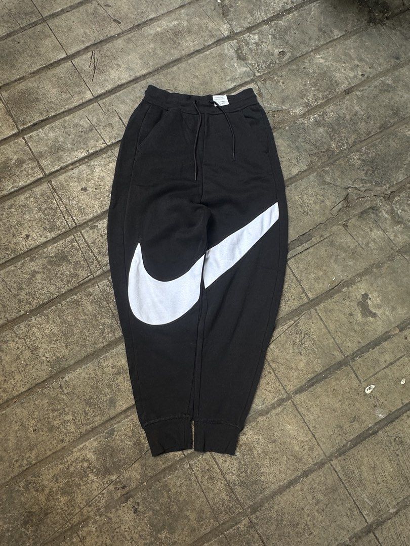 Nike Big Swoosh Black Sweatpants (Category: Joggers) located in Lapu Lapu. Submitted by gabocamaon03138 (Listing ID 1465236259, Image 1). Description: - Brand: Nike - Color: Black with giant white wrap-around Swoosh logo - Size: XS - Material: Super comfy fleece lining - Features: Adjustable drawstring waistband, ribbed ankle cuffs, and a right-side back pocket - Condition: Excellent / Ready to wear - Perfect for: Casual lounging, gym, or streetw