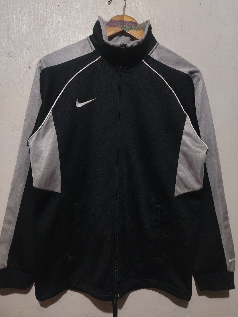 Nike Black Grey Track Jacket Full Zip (Category: Coats, Jackets and Outerwear) located in Rizal. Submitted by gmpastoffi75031 (Listing ID 1465312429, Image 1). Description: - Brand: Nike -dimes 21.5x27.5 - Colorway: Black and grey with contrast white piping - Features: Full zip front, stand-up collar, dual front pockets - Details: Ribbed cuffs and hem, embroidered white Swoosh logo on right chest - Condition: Excellent pre-loved condition - Mode 