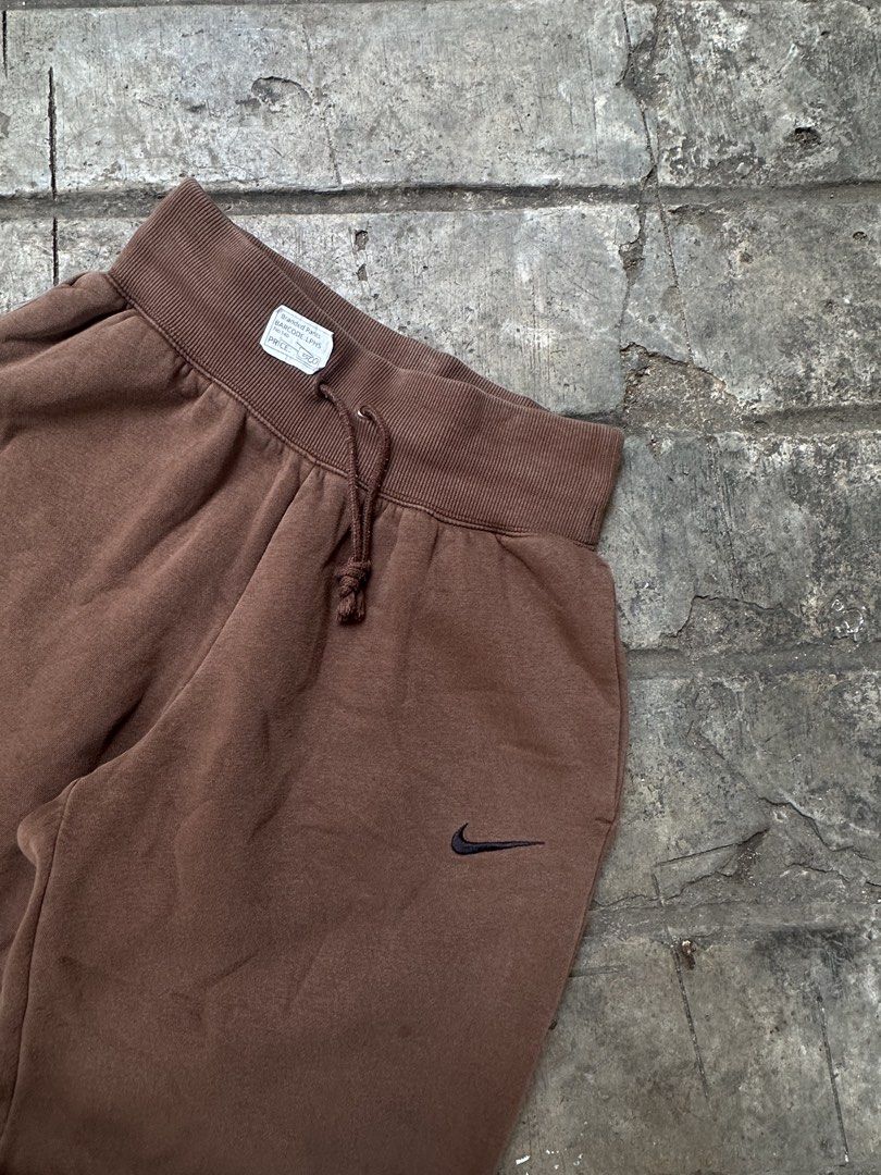 Nike Brown Joggers Sweatpants (Category: Joggers) located in Lapu Lapu. Submitted by gabocamaon03138 (Listing ID 1465236452, Image 2). Description: - Color: Brown - Brand: Nike - Fit: Relaxed baggy fit through the legs - Details: Small embroidered black swoosh logo on the left hip - Waistband: Adjustable drawstring with thick ribbed waist - Cuffs: Ribbed cuffs at the ankles - Condition: Super comfortable everyday loungewear.
