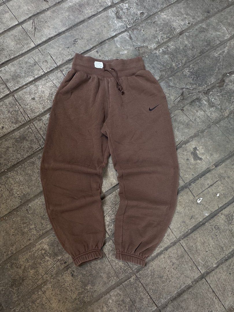Nike Brown Joggers Sweatpants (Category: Joggers) located in Lapu Lapu. Submitted by gabocamaon03138 (Listing ID 1465236452, Image 1). Description: - Color: Brown - Brand: Nike - Fit: Relaxed baggy fit through the legs - Details: Small embroidered black swoosh logo on the left hip - Waistband: Adjustable drawstring with thick ribbed waist - Cuffs: Ribbed cuffs at the ankles - Condition: Super comfortable everyday loungewear.