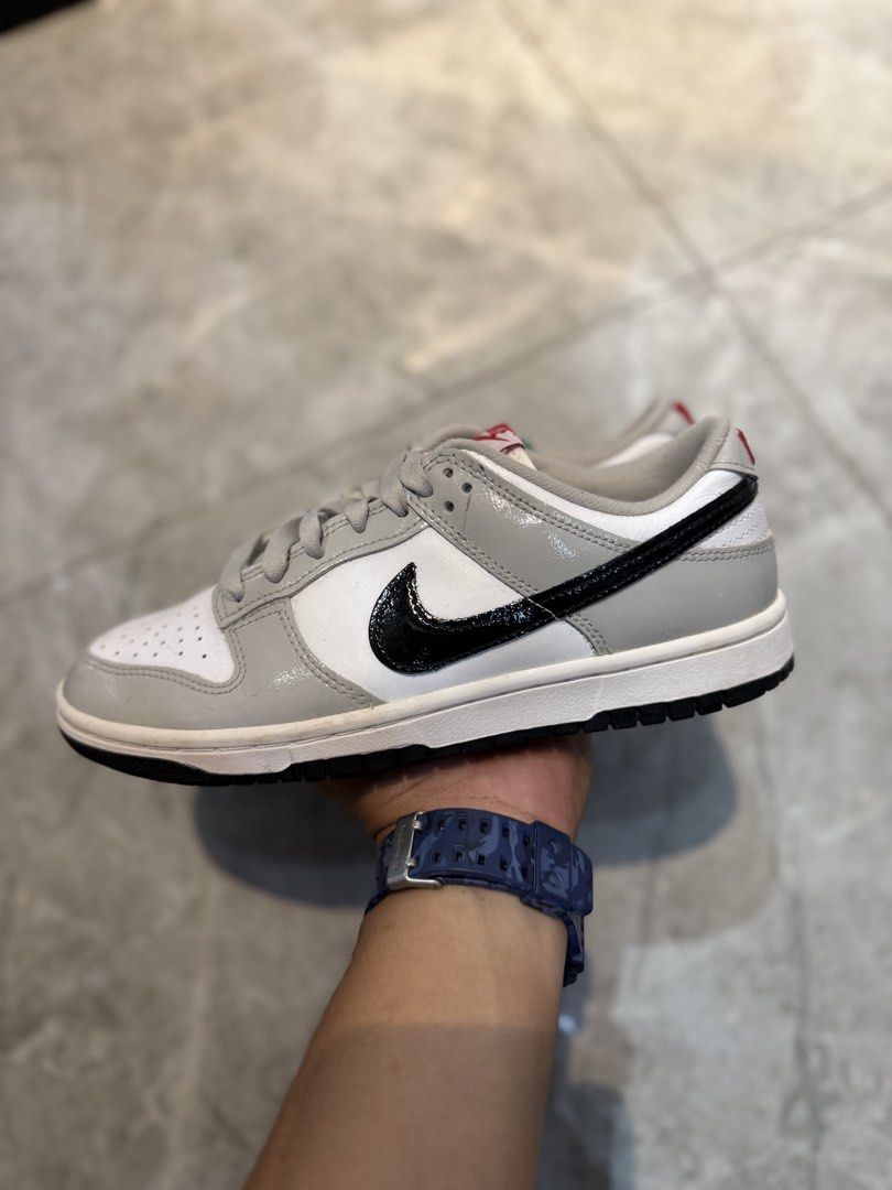 Nike Dunk Low Grey Patent Black Swoosh (Category: Sneakers) located in Bacolod City. Submitted by kitcarsonduff (Listing ID 1465323783, Image 1). Description: - Model: Nike Dunk Low - Colorway: White leather base with grey patent leather overlays and black patent swoosh - Details: Red Nike branding on the tongue tag and embroidered heel tab with a solid black rubber outsole - Condition: Clean soles with minimal wear - Style: Classic low-top baske
