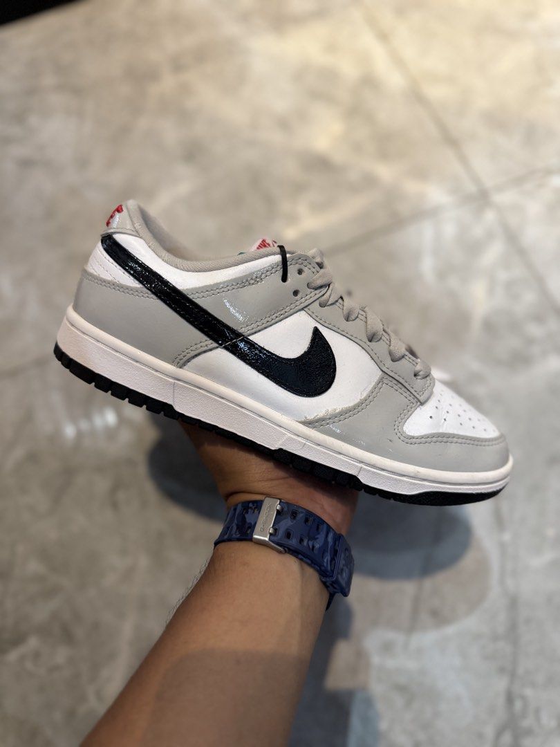 Nike Dunk Low Grey Patent Black Swoosh (Category: Sneakers) located in Bacolod City. Submitted by kitcarsonduff (Listing ID 1465323783, Image 3). Description: - Model: Nike Dunk Low - Colorway: White leather base with grey patent leather overlays and black patent swoosh - Details: Red Nike branding on the tongue tag and embroidered heel tab with a solid black rubber outsole - Condition: Clean soles with minimal wear - Style: Classic low-top baske