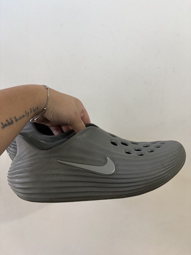 Nike Reactx (Category: Slippers & Slides) located in Manila. Submitted by roccolini (Listing ID 1465233160, Image 1). Description: - Color: Grey - Style: Slip-on clogs with ventilation holes for breathability - Design: Wavy ridged texture on sides and back heel with metallic silver Nike swoosh - Sole: Textured circular pattern for grip - Material: Comfortable, water-friendly, and easy to clean - Condition: Brand new / Great for everyday use 100% 