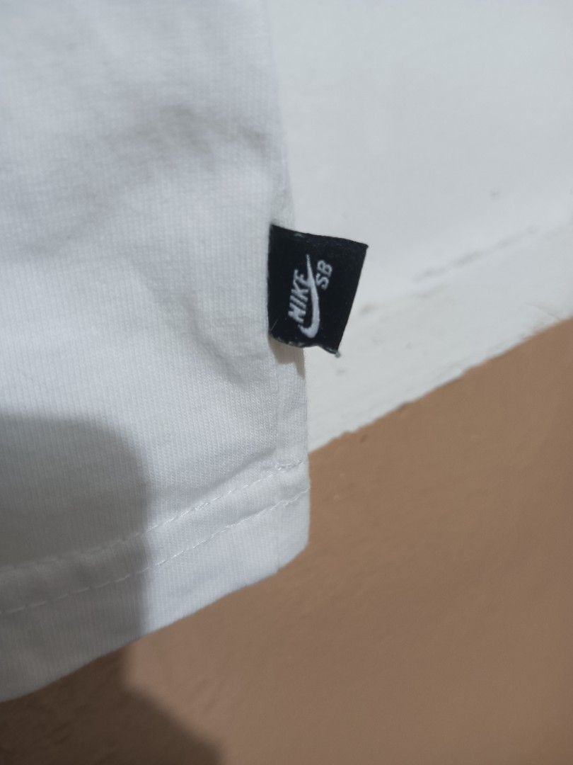 Nike SB White T-Shirt (Category: Tshirts & Polo Shirts ) located in Davao. Submitted by jasondagam14678 (Listing ID 1465380186, Image 2). Description: - Authentic white Nike SB t-shirt - Features a bold black chest logo and small woven tag near the hem - Classic crew neck and short sleeves - Standard fit for comfortable wear - Excellent, clean condition with no stains or rips - Versatile streetwear piece, great for daily use or skating - Dimensio