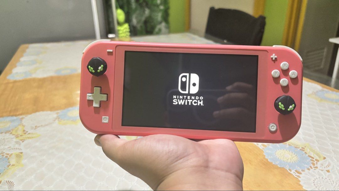 Nintendo Switch Lite Coral Pink Handheld Console (Category: Nintendo) located in Manila. Submitted by raiji9042 (Listing ID 1465173402, Image 3). Description: Coral pink Nintendo Switch Lite console. Works great, powers on normally with Pokémon Unite loaded on the screen. Black thumb grips with green alien patterns installed on both joysticks. Clean screen. Buttons and thumbsticks fully responsive..