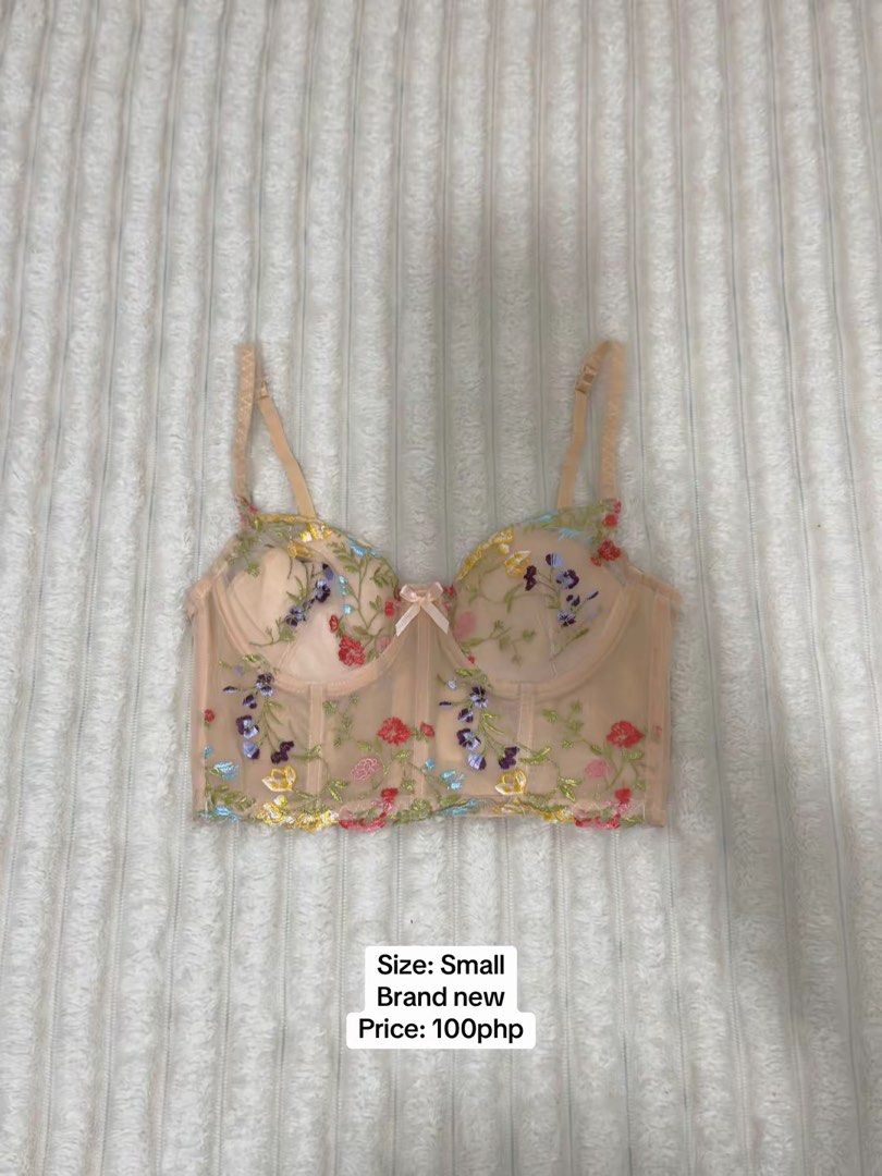 Nude Mesh Floral Embroidered Bustier Top Small (Category: Sleeveless) located in Pasig City. Submitted by jamie.sebuc (Listing ID 1465237746, Image 1). Description: - Condition: Brand new, never worn - Size: Small - Design: Nude sheer mesh with colorful floral embroidery and center front ribbon bow - Support: Underwire cups and adjustable shoulder straps - Closure: Back hook-and-eye closure.