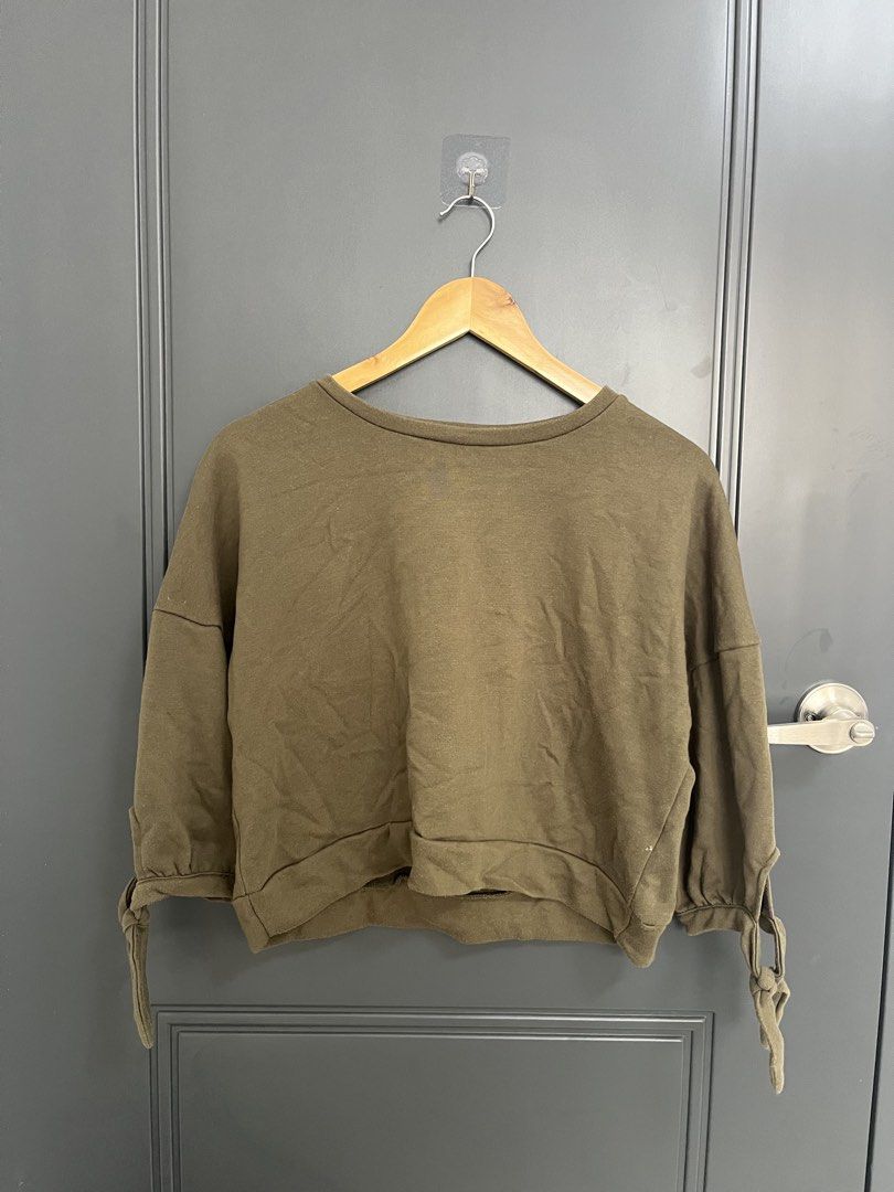 Olive Green Cropped Sweatshirt With Tie Sleeves (Category: Coats, Jackets and Outerwear) located in Angeles City. Submitted by mochimochi1219 (Listing ID 1465198701, Image 1). Description: - Color: Olive green - Fit: Relaxed, cropped with a gathered hemline - Material: Soft, comfortable cotton blend - Details: 3/4 length sleeves with cute ribbon tie cuffs and wide rounded neckline - Condition: Clean and ready to wear - Styling: Perfect to pair wi