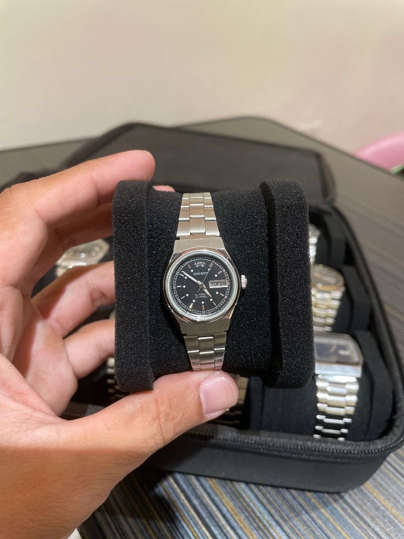 Orient Automatic Black Dial Steel Watch (Category: Men's Watches) located in Davao. Submitted by horadvo_2026 (Listing ID 1465364049, Image 1). Description: Orient automatic watch with a classic black dial and stainless steel bracelet. Day and date window sits at the 3 o'clock position. Silver-tone case and matching link band with a secure clasp. Automatic movement visible through the exhibition case back. Wears comfortably on the wrist. Versatil