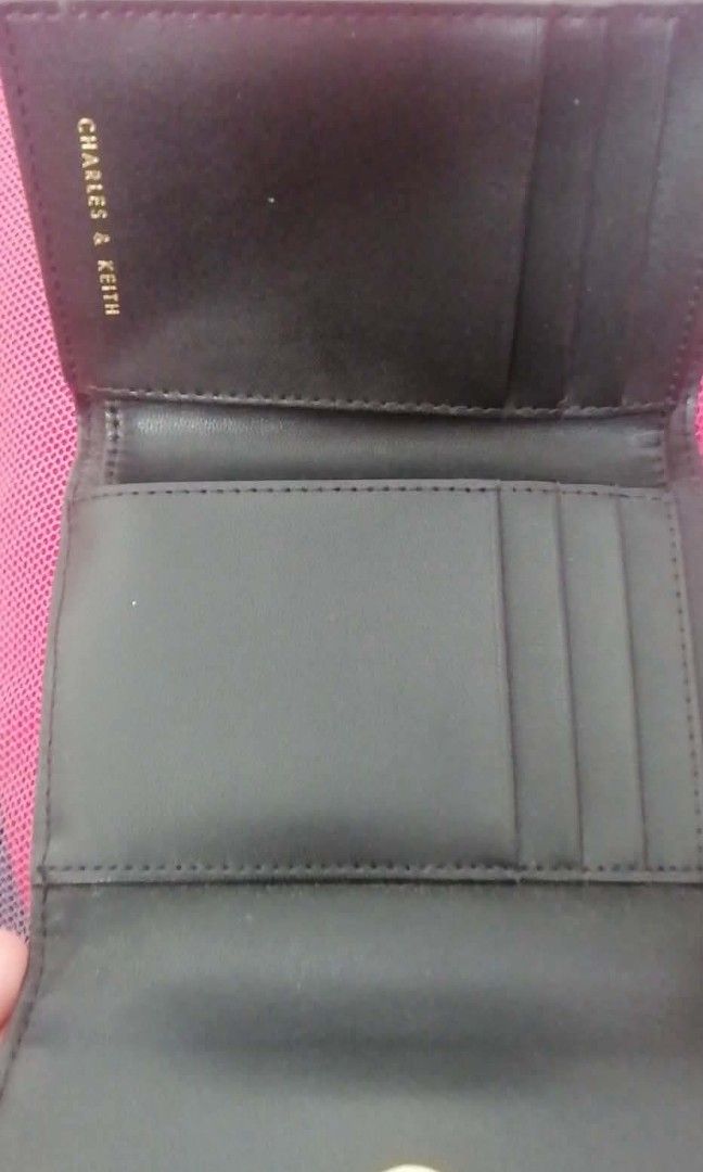 Original Charles & Keith Black Tri-fold Wallet - 100% Authentic (Category: Wallets & Card holders) located in Manila. Submitted by roseannlmn66895 (Listing ID 1464235567, Image 3). Description: *CHARLES & KEITH Wallet - Black* Tri-fold long wallet, black color, gold buckle and gold zipper. Faux leather, makinis, no bakbak. May card slots, bill compartment, coin zipper. With CHARLES & KEITH engrave sa zipper at emboss sa loob. Good as new, malinis