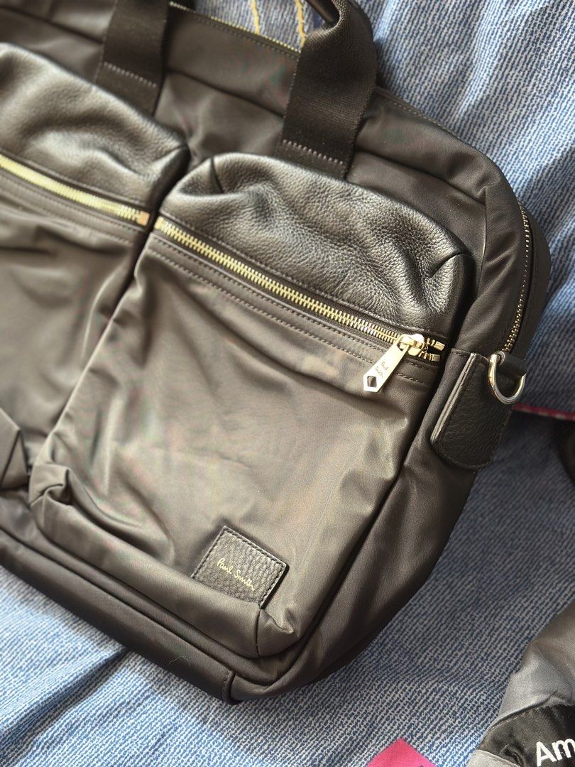 Paul Smith Black Nylon Leather Trim Briefcase (Category: Briefcases) located in Batangas. Submitted by enyahsnivl56498 (Listing ID 1465180584, Image 1). Description: - Brand: Paul Smith - Material: Durable black nylon with textured leather accents - Hardware: Premium gold-tone hardware with custom Paul Smith zipper pulls and D-rings - Handles: Twin carry handles with comfortable leather grip sections - Interior: Multiple compartments, slip pocket