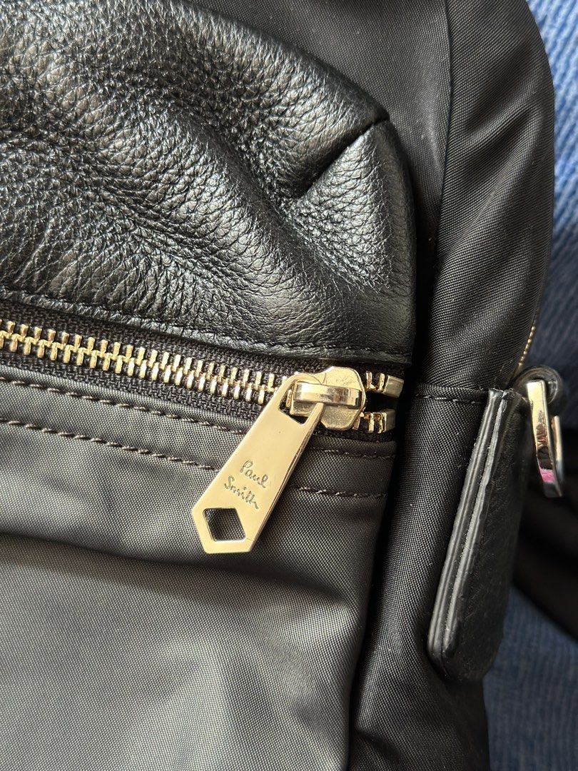 Paul Smith Black Nylon Leather Trim Briefcase (Category: Briefcases) located in Batangas. Submitted by enyahsnivl56498 (Listing ID 1465180584, Image 2). Description: - Brand: Paul Smith - Material: Durable black nylon with textured leather accents - Hardware: Premium gold-tone hardware with custom Paul Smith zipper pulls and D-rings - Handles: Twin carry handles with comfortable leather grip sections - Interior: Multiple compartments, slip pocket