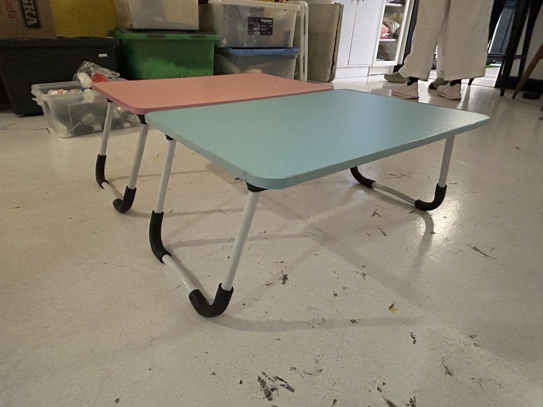 Pink and Blue Foldable Laptop Study Tables (Category: Tables & Sets) located in Quezon City. Submitted by ccr26 (Listing ID 1465306112, Image 1). Description: USED ONCE FOR SHOOT ONLY TAKE BOTH FOR 1200 - Set of 2 portable study desks (1 Pink, 1 Light Blue) - Features convenient foldable legs for easy storage - Sturdy metal frames with black protective corner grips - Compact size ideal for working on the bed or floor - Stackable design folds comp