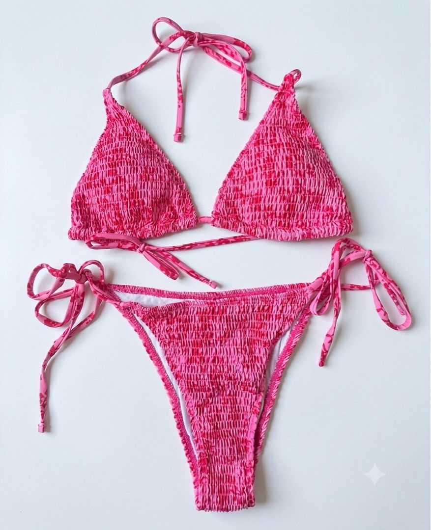 Pink Floral Smocked Halter Bikini Set (Category: Bikinis & Swimsuits) located in Manila. Submitted by ynaamo (Listing ID 1465256841, Image 1). Description: - Style: Bright pink two-piece swimsuit with all-over floral print - Top: Triangle halter style with adjustable neck and back ties - Bottoms: Low-rise with adjustable side tie closures - Material: Stretchy smocked fabric throughout, fully lined interior - Condition: Brand new / Excellent quali