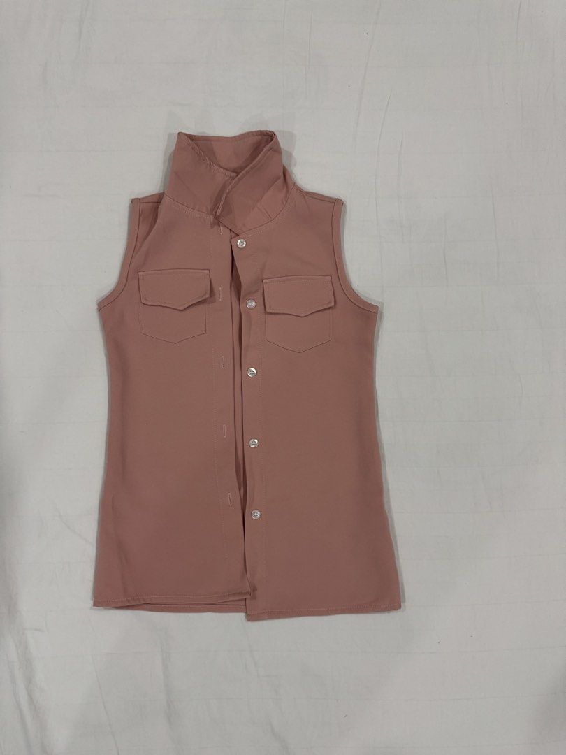 Pink high neck sleeveless buttoned vest (Category: Babies & Kids Fashion) located in Manila. Submitted by crazycat13 (Listing ID 1465171755, Image 1). Description: - Color: Dusty pink - Style: Sleeveless vest with a high collar neck - Closure: Front button closure with light buttons - Pockets: Two chest pockets with flaps - Hemline: Straight - Material: Smooth fabric - Versatility: Great for layering over shirts or wearing on its own.